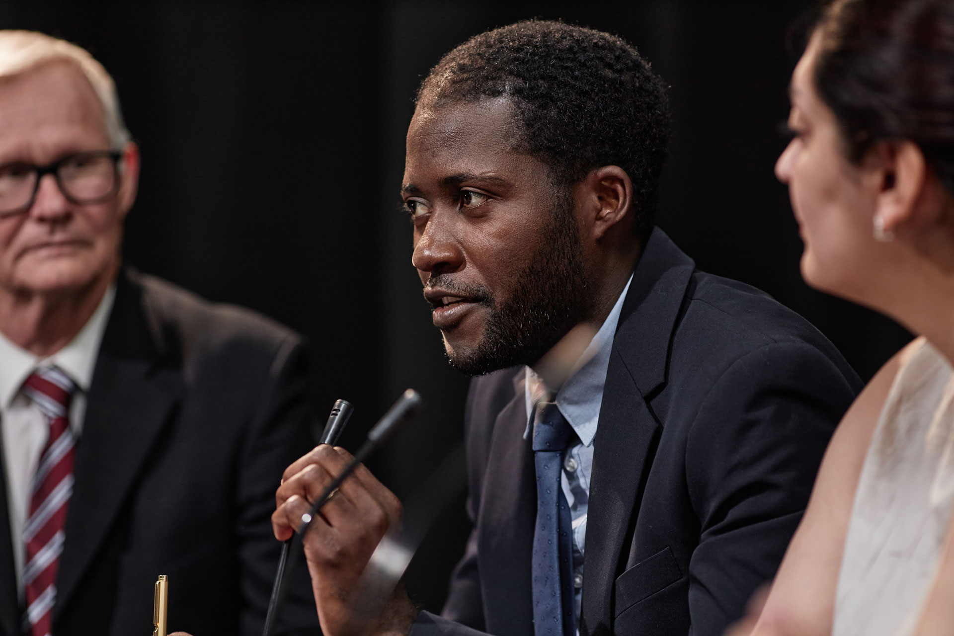 confident man speaking into microphone giving report to fellow board members