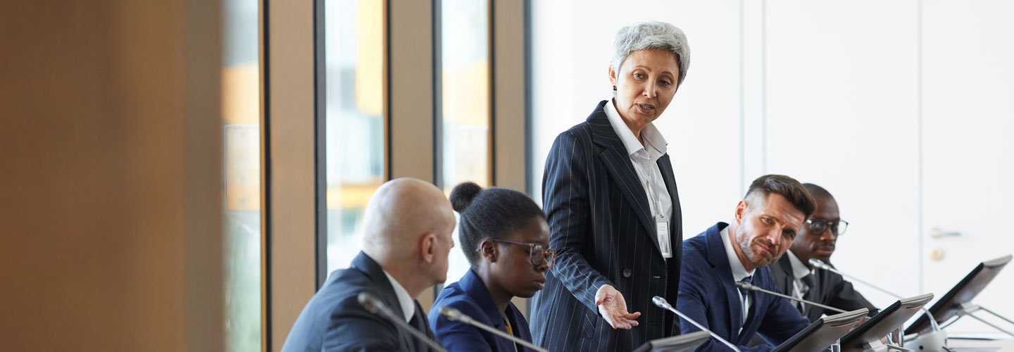 Woman speaking during business conference at board room.